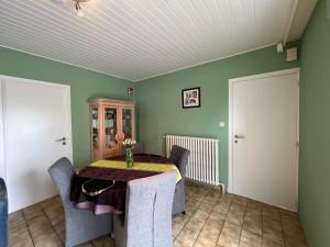 a dining room with a table and chairs and green walls at Villa Gaupin in Oostduinkerke