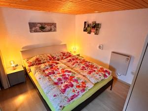 Un dormitorio con una cama con flores. en Bijouswiss " Yellow House", en Oberterzen