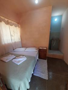 1 dormitorio con 1 cama con 2 toallas en Espaço Bella Ville en Alto Caparao