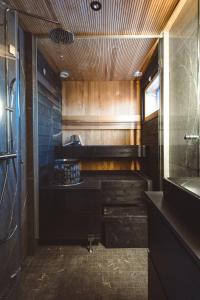 baño con encimera negra y lavamanos en Glass Ceiling Suite Kipinä, en Sirkka