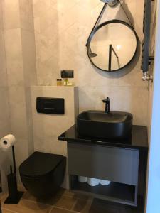 a bathroom with a black sink and a toilet at Barwny Zakątek in Augustów