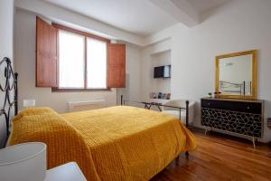 een slaapkamer met een bed met een gele deken bij Ciompi Square-Hosted by Sweetstay in Florence