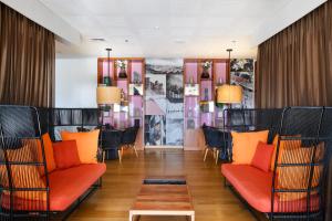 um restaurante com cadeiras laranja e uma mesa num quarto em Noga by Isrotel Collection - The Renewed Ganim Hotel em Ein Bokek