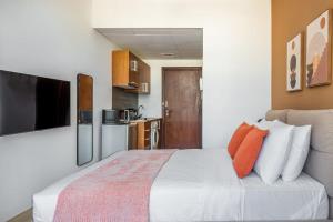 a bedroom with a large white bed with orange pillows at Silkhaus cozy studio in heart of DIFC Burj Daman in Dubai