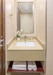 a bathroom with a sink and a mirror and towels at Silkhaus elegant studio with Burj Khalifa view and balcony in Dubai