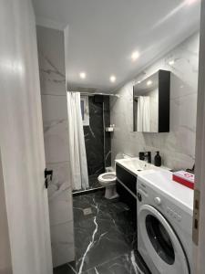 ein Badezimmer mit einer Waschmaschine und einem WC in der Unterkunft Hana Holiday Beach Apartment 1 in Artemida