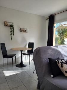 a living room with a table and chairs and a couch at Abrivado Appartements meublés dans une grande propriété en rez de jardin in Aimargues