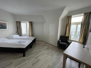 um quarto de hotel com uma cama e uma cadeira em P-Hotels Oslo em Oslo