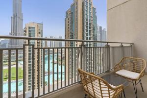 einen Balkon mit 2 Stühlen und Stadtblick in der Unterkunft Silkhaus with full Burj Khalifa & fountain view 1BDR in Downtown in Dubai
