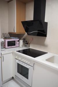 y cocina con microondas y fogones. horno superior en Moderno apartamento con garaje privado en el centro de Vigo, en Vigo