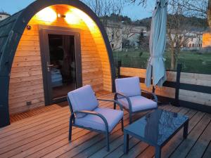 2 sillas y una sombrilla en una terraza de madera en Chez Fabien et Céline, en Aunat