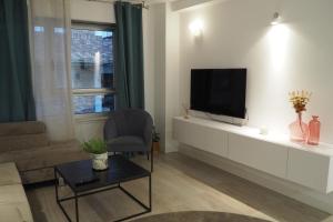 sala de estar con TV de pantalla plana en la pared en Moderno apartamento con garaje privado en el centro de Vigo, en Vigo