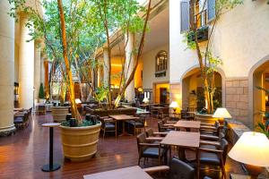a restaurant with tables and chairs and trees at Oriental Hotel Tokyo Bay in Urayasu +99 photos