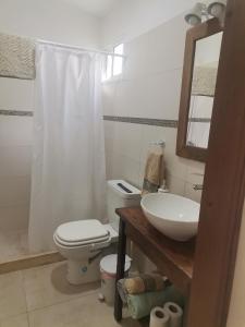 y baño con aseo, lavabo y espejo. en MANDALA HOME, en Durazno