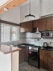 uma cozinha com fogão e micro-ondas em MANDALA HOME em Durazno