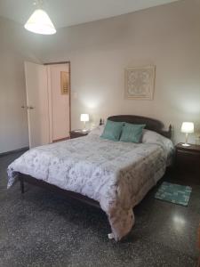 um quarto com uma cama grande com 2 mesas e 2 candeeiros em MANDALA HOME em Durazno