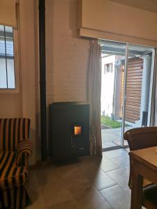 a living room with a fireplace and a chair at MANDALA HOME in Durazno