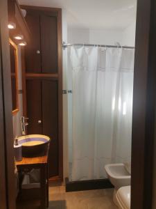 ein Bad mit einer Dusche, einem Waschbecken und einem WC in der Unterkunft MANDALA HOME in Durazno