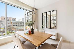 a dining room with a wooden table and chairs at Silkhaus Modern 1BDR in Marina Close to Beach in Dubai