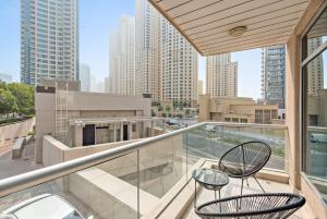 a balcony with two chairs and a view of a city at Silkhaus Modern 1BDR in Marina Close to Beach in Dubai