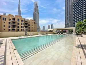 a large swimming pool on top of a building at Silkhaus MOST EXCLUSIVE! FULL Burj Khalifa & Fountains view in Dubai