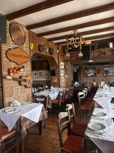 um restaurante com mesas e cadeiras com toalha de mesa branca em Hana Holiday Beach Apartment 1 em Artemida