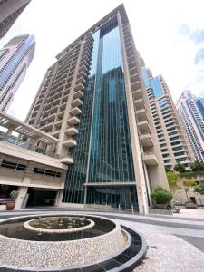 een hoog gebouw met een fontein ervoor bij Silkhaus lovely studio with Downtown view in Boulevard central in Dubai
