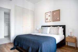 a bedroom with a large bed with a blue blanket at Blueground Dreta de lEixample nr pl catalunya BCN-42 in Barcelona