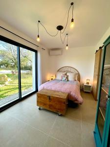 a bedroom with a bed and a large window at Maison à la campagne 4 personnes in Montauroux