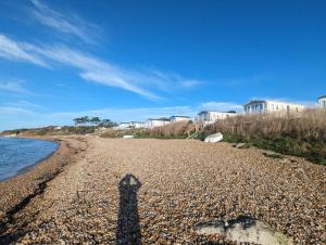 a shadow of a person standing on a beach at Pemberton Avon pitch 30 Creek Caravan Park dog friendly in Ringstead