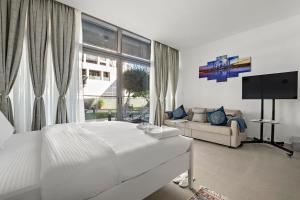 - une chambre blanche avec un lit et un canapé dans l'établissement Silkhaus Luxury studio in Saadiyat Island, à Abu Dhabi