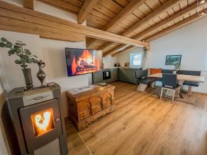 a living room with a fireplace and a dining room at Alpine Apartments St-Sigmund in Sankt Sigmund im Sellrain