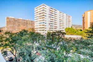 a tall white building with trees in front of it at Blueground Pedralbes balcony swimming pool BCN-124 in Barcelona