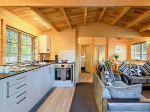 a kitchen and living room in a log cabin at 2 Bed in Saxmundham 89929 in Snape
