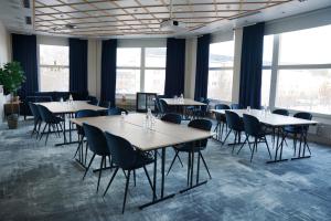 a dining room with tables and chairs and windows at Quality Hotel Sundsvall in Sundsvall