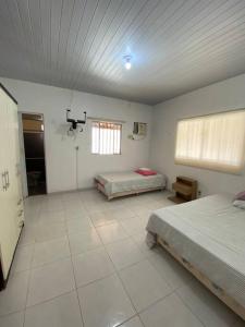 a large room with two beds and a window at Chalé de Praia - Salinopolis/Pa in Salinópolis +10 photos