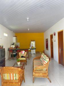 a living room with wicker chairs and a tv at Chalé de Praia - Salinopolis/Pa in Salinópolis
