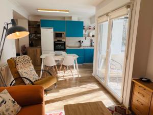a living room and kitchen with blue cabinets and a table at Itsasoa by Basque Homes in Donostia-San Sebastián