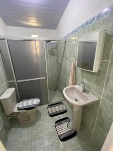 a bathroom with a sink and a toilet and a shower at Chalé de Praia - Salinopolis/Pa in Salinópolis
