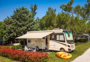 罗维尼Maistra Camping Polari Pitches的露营车停在一个有帐篷的院子内