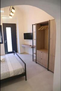 ein Schlafzimmer mit einem Bett, einem Schrank und einem TV in der Unterkunft Locus Pendinelli Trani in Trani