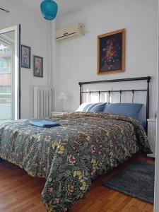 a bedroom with a bed with a floral bedspread at Panormou studio comfortable max two guests in Athens