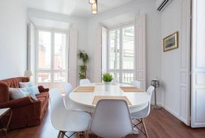 マラガにあるSunny Málaga Apartmentsの白いダイニングルーム(白いテーブルと椅子付)
