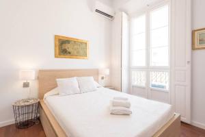 マラガにあるSunny Málaga Apartmentsの白いベッドルーム(白いシーツを使用した大型ベッド1台付)