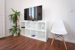 - un centre de divertissement blanc avec une télévision et une chaise blanche dans l'établissement Sunny Málaga Apartments, à Malaga