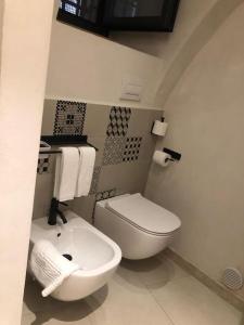 ein Badezimmer mit einem weißen WC und einem Waschbecken in der Unterkunft Locus Pendinelli Trani in Trani