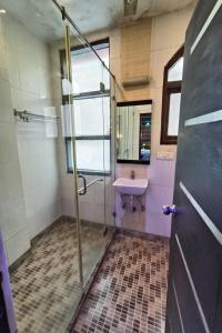 een badkamer met een glazen douche en een wastafel bij Hotel Vardhmaan Inn in New Delhi