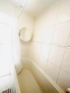 baño blanco con bañera y ventana en K court , 18 en Londres