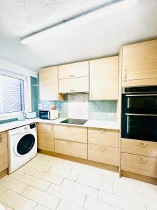 cocina con armarios de madera y lavavajillas en K court , 18 en Londres