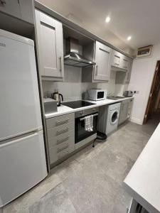 a kitchen with white cabinets and a sink and a dishwasher at Boutique Style Apartment Belfast in Belfast